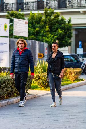 Couple walking on the sidewalk of Victoriei Way (Calea Victoriei) in Bucharest, Romania, 2019のeditorial素材