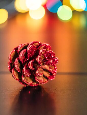 Christmas decoration and ornaments. Christmas composition on blurred lights background. Glittery pine cone.の写真素材