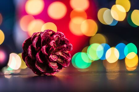 Christmas decoration and ornaments. Christmas composition on blurred lights background. Glittery pine cone.の写真素材