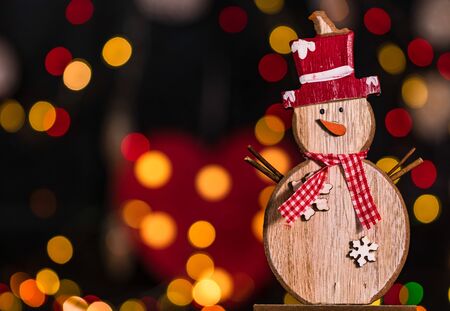 Christmas decoration and ornaments. Christmas composition on blurred lights background. Wooden Christmas snowman.の写真素材