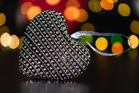 Christmas decoration and ornaments. Christmas composition on blurred lights background. Heart shaped Christmas ball.の写真素材