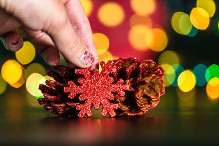 Christmas decoration and ornaments. Christmas composition on blurred lights background. hand putting Christmas decorations on table.の写真素材