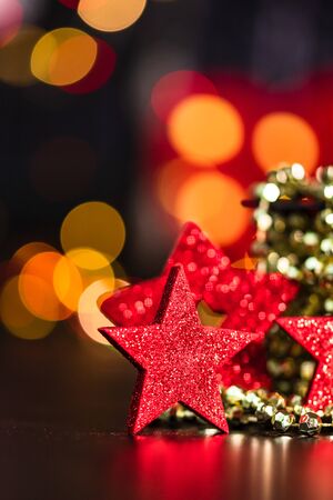 Christmas decoration and ornaments. Christmas composition on blurred lights background. Red and glittery decorations.の写真素材