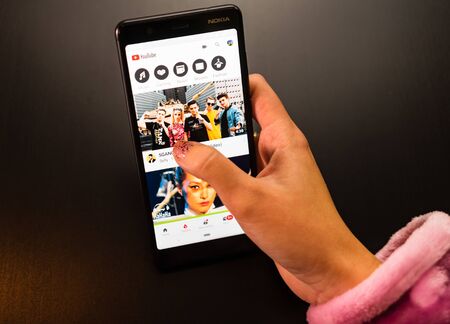 Woman holding a Nokia phone with social Internet service YouTube on the screen in Bucharest, Romania, 2019のeditorial素材