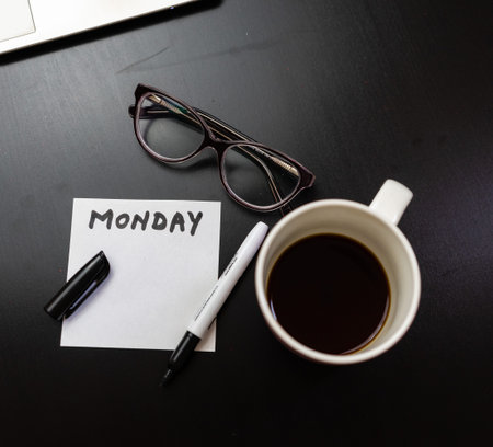 Different objects on black office desk. Modern black office desk table with keyboard, sticky note...