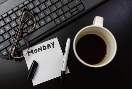 Different objects on black office desk. Modern black office desk table with keyboard, sticky note...