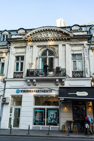 Man on balcony talking at his mobile phone in Bucharest, Romania, 2019のeditorial素材