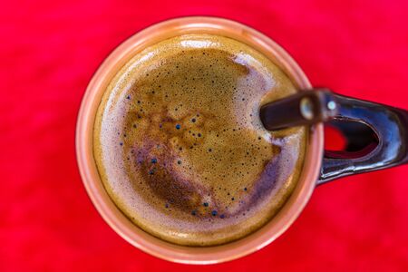 Top view of cup of creamy expresso coffee on red background.の写真素材