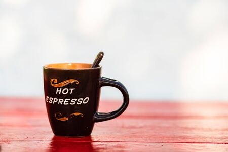 Cup of creamy homemade expresso coffee on red wooden board.の写真素材