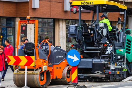 Workers in overalls in an autumn morning repair the street on the main boulevard Victoriei (Calea Victoriei) in downtown Bucharest, Romania, 2019のeditorial素材