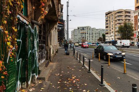 Man with carry on walking in the morning on the sidewalk in downtown Bucharest, Romania, 2019のeditorial素材