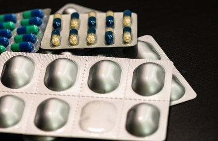 Multicolor vitamins and supplements on black background. Concept for a healthy dietary...