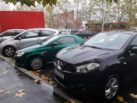 Cars parked along the street with autumn leaves on the ground in Bucharest, Romania, 2019のeditorial素材