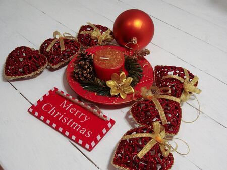 Christmas decorations on white board. Christmas concept, decorated Christmas candle and glittery Christmas ornaments.の写真素材