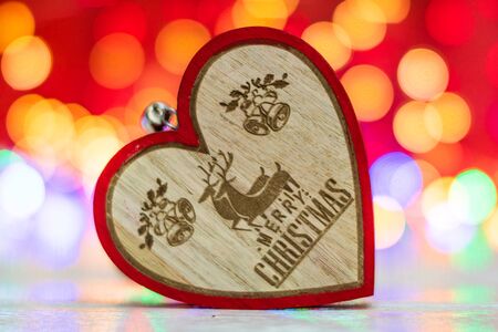 Wooden heart shaped Christmas ornament. Christmas decorations on blurred lights background.の写真素材