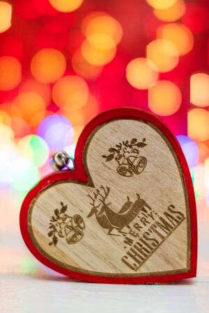 Wooden heart shaped Christmas ornament. Christmas decorations on blurred lights background.の写真素材