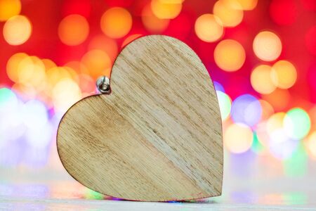 Wooden heart shaped Christmas ornament. Christmas decorations on blurred lights background.の写真素材