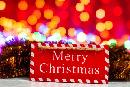 Merry Christmas wooden sign. Christmas composition on blurred lights background.の写真素材