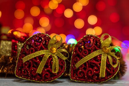 Glittery heart shaped Christmas balls. Christmas decorations on blurred lights background.の写真素材