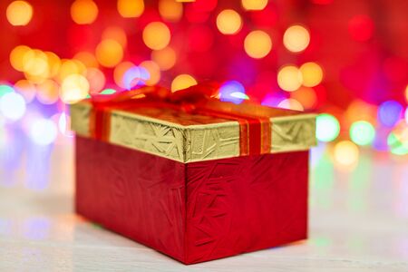 Christmas gift box, close up photo. Christmas composition on blurred lights background.の写真素材