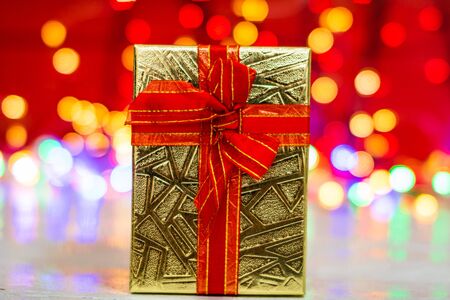 Christmas gift box, close up photo. Christmas composition on blurred lights background.の写真素材