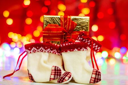 Christmas gift box and small Christmas stockings. Christmas composition on blurred lights background.の写真素材