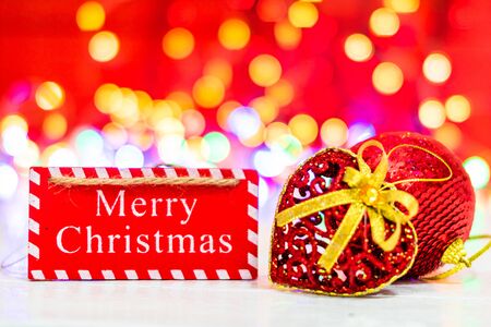 Merry Christmas wooden sign. Christmas composition on blurred lights background. Colorful Christmas balls.の写真素材