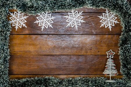 Christmas composition on wooden board with Christmas garland and decorations. Creative composition with border and copy space, top view, flat lay. Christmas frame.の写真素材