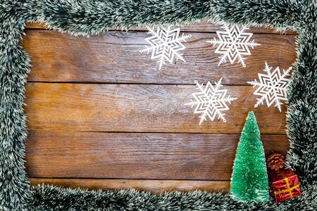 Christmas composition on wooden board with Christmas garland and decorations. Creative composition with border and copy space, top view, flat lay. Christmas frame.の写真素材