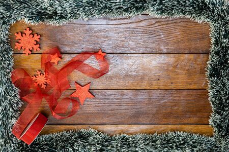 Christmas composition on wooden board with Christmas garland and decorations. Creative composition with border and copy space, top view, flat lay. Christmas frame.の写真素材