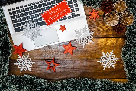 Merry Christmas wooden sign on keyboard. Christmas decorations on wooden table. Christmas concept.の写真素材