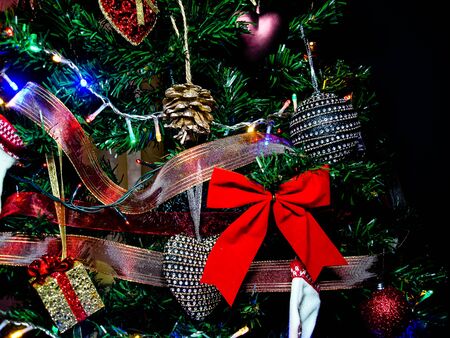 Christmas hanging decorations. Decorated Christmas tree with balls, garlands and lights. Fir branches with Christmas decorations.の写真素材