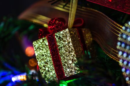 Christmas hanging decorations on fir tree. Decorated Christmas tree. Fir branch with gift decorationの写真素材