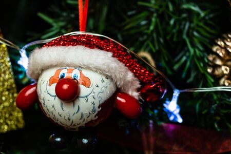 Christmas hanging decorations on fir tree. Decorated Christmas tree. Fir branches with Santa Claus figurine.の写真素材