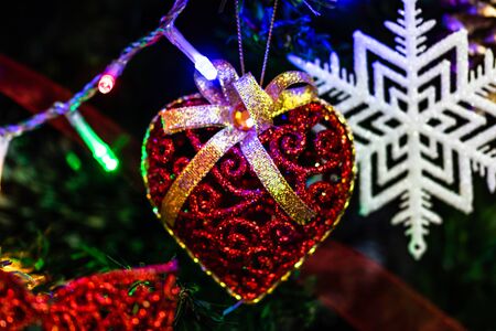 Christmas hanging decorations on fir tree. Decorated Christmas tree. Fir branch with Christmas heart shaped decoration.の写真素材