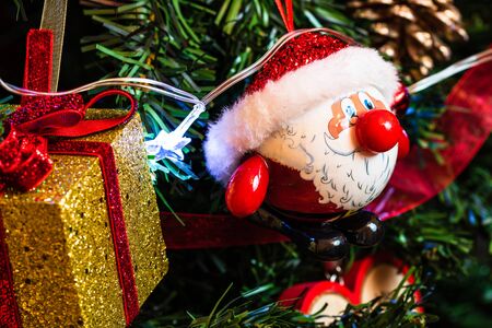 Christmas hanging decorations on fir tree. Decorated Christmas tree. Fir branches with Santa Claus figurine.の写真素材