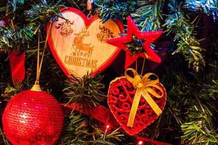 Christmas hanging decorations on fir tree. Decorated Christmas tree. Fir branch with Christmas heart shaped decoration.の写真素材