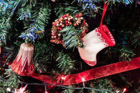 Christmas hanging decorations on fir tree. Decorated Christmas tree. Fir branch with Christmas decorations surrounded by lights and garlands.の写真素材