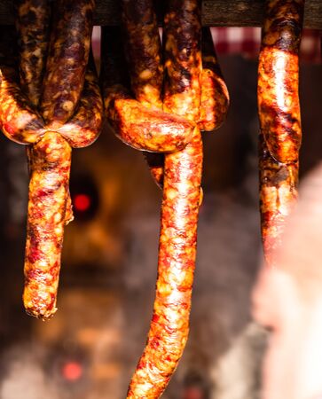 Traditional smoked pork meat products hanging in for sale at the winter Christmas market in Bucharest.の写真素材
