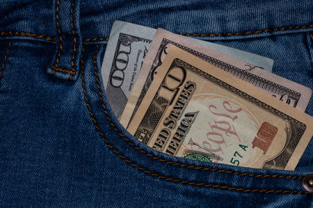 Banknotes, money in a jeans pocket, close up. Money stick out of the jeans pocket, finance and...