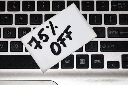 Text 75% off on white label. Label on keyboard, close up.