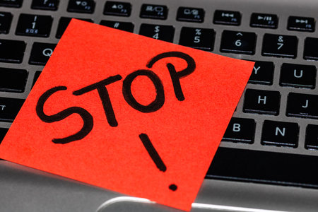 Writing on colorful sticky note Stop. Text with Stop on paper.