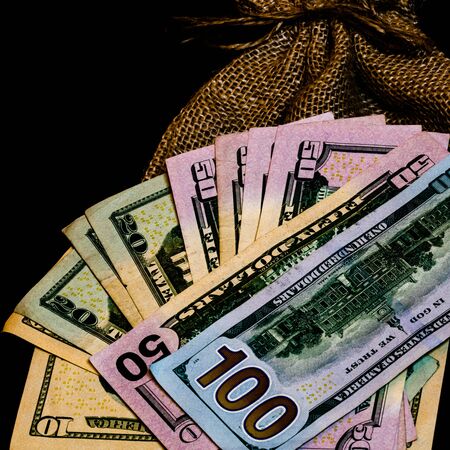 Cash bag, burlap sack and dollars money isolated.の写真素材
