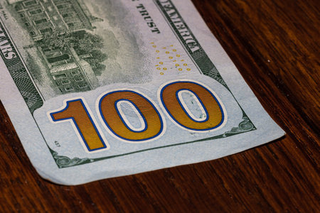 Detail on 100 dollars banknote. Close up of banknote laid out on table.