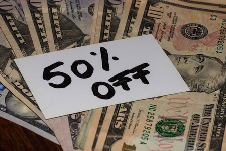 50% Off text on white label, label on dollars money.