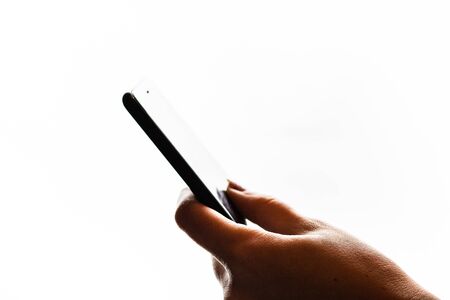 Woman hand holding a black smartphone in her hand. Teenage girl using a touchscreen smartphone, isolated on whiteの写真素材