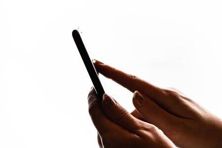 Woman hand holding a black smartphone in her hand. Teenage girl using a touchscreen smartphone, isolated on whiteの写真素材
