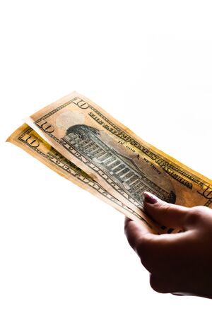 Woman hand giving money like bribe or tips isolated on white background. USD currency banknotes close up. Reward for hard work, finance and business conceptの写真素材