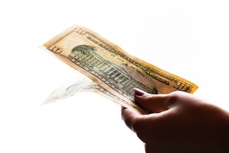Woman hand giving money like bribe or tips isolated on white background. USD currency banknotes close up. Reward for hard work, finance and business conceptの写真素材