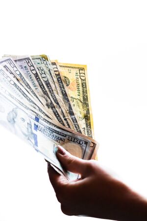 Woman hand giving money like bribe or tips isolated on white background. USD currency banknotes close up. Reward for hard work, finance and business conceptの写真素材